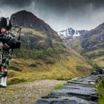 Traditional bagpiper in the scottish highlands by Glencoe